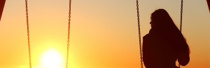 woman on swing at sunset